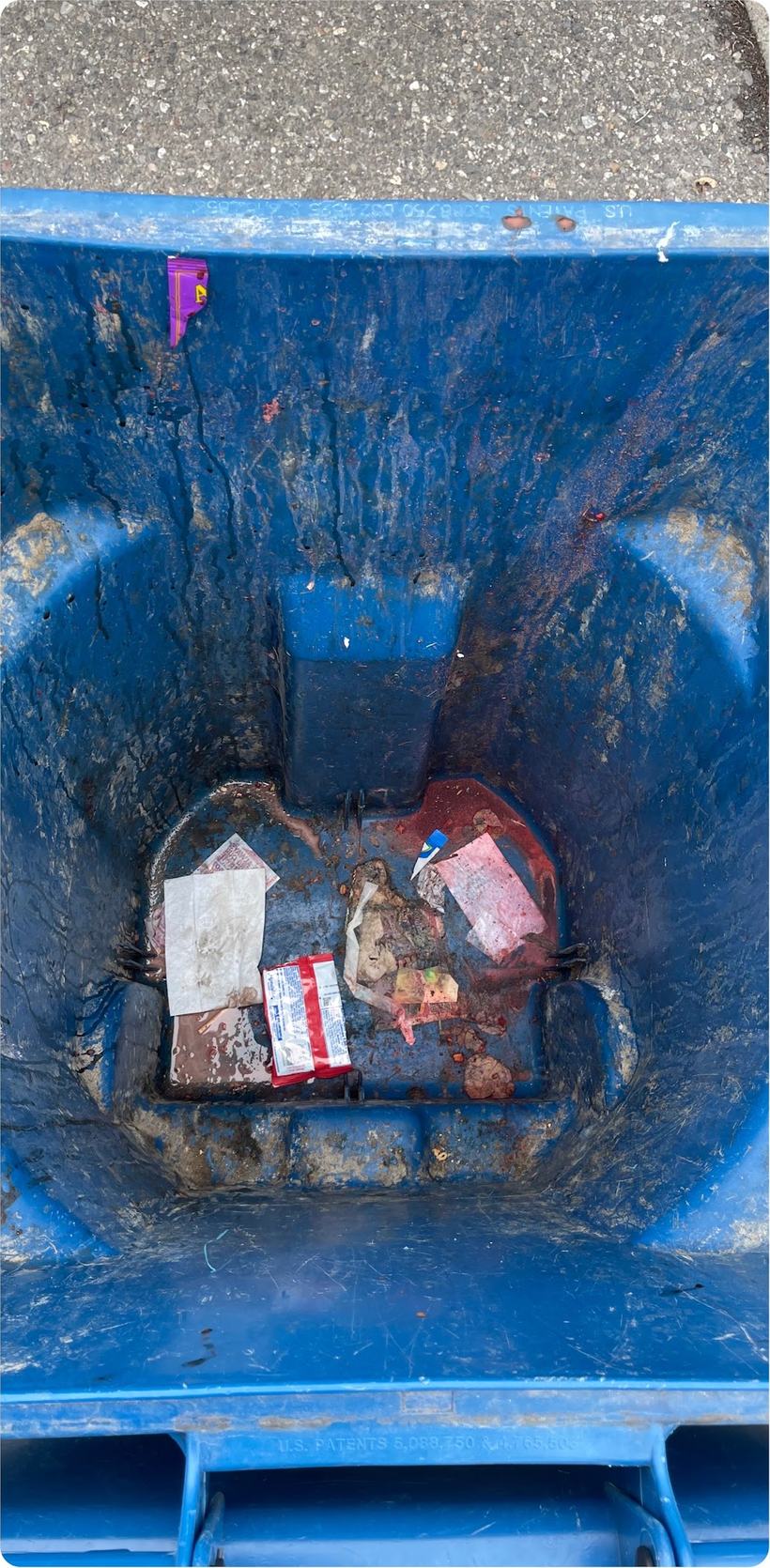 A wheelie bin caked with residue and debris before cleaning