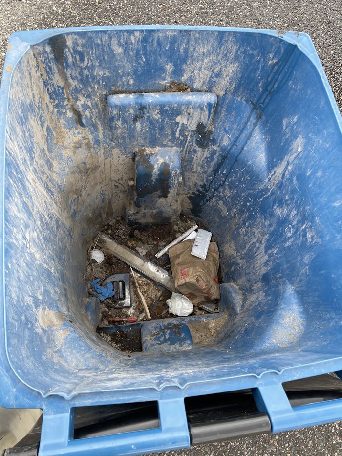 Residue and debris inside a neglected wheelie bin