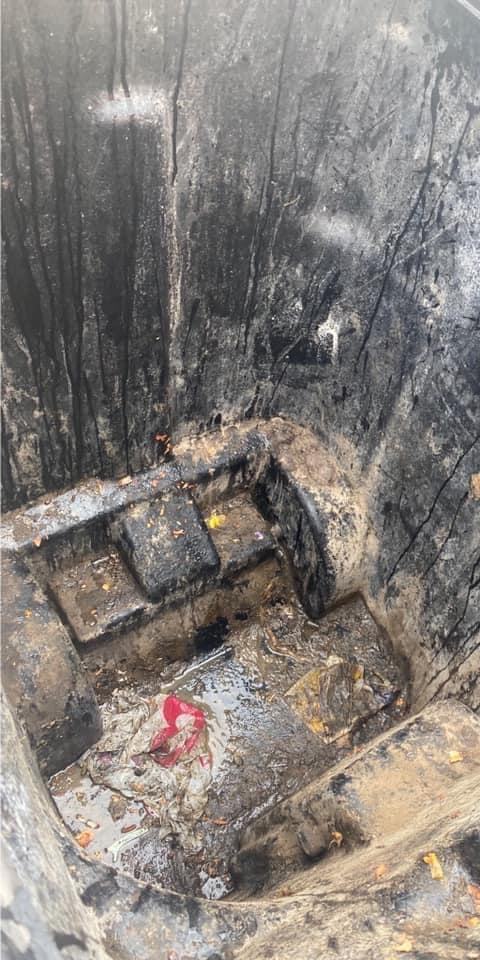 A commercial dumpster interior thick with residue before cleaning