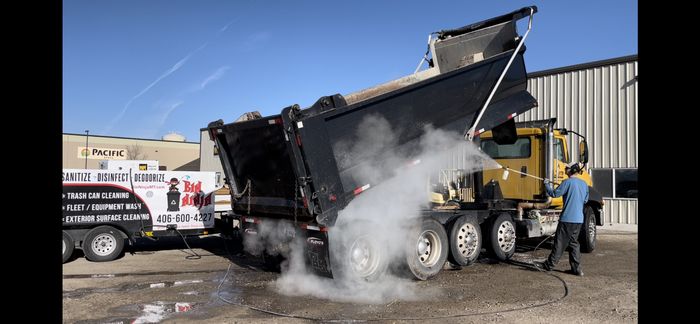 Hot water and steam blasting the bed of a dump truck