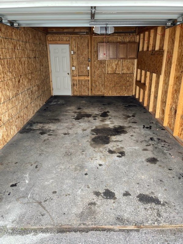 An oil-stained garage floor before cleaning