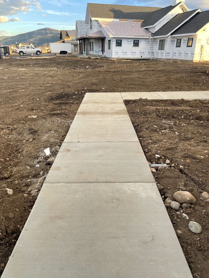 A concrete walkway running alongside a new build
